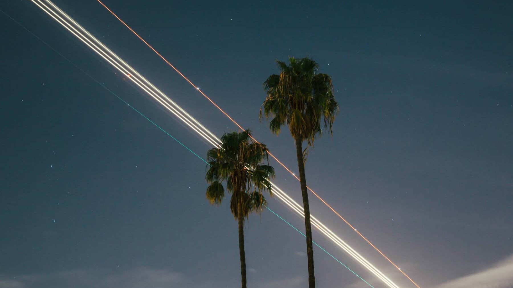LAX durante la noche con luz de avión de larga exposición + palmeras
