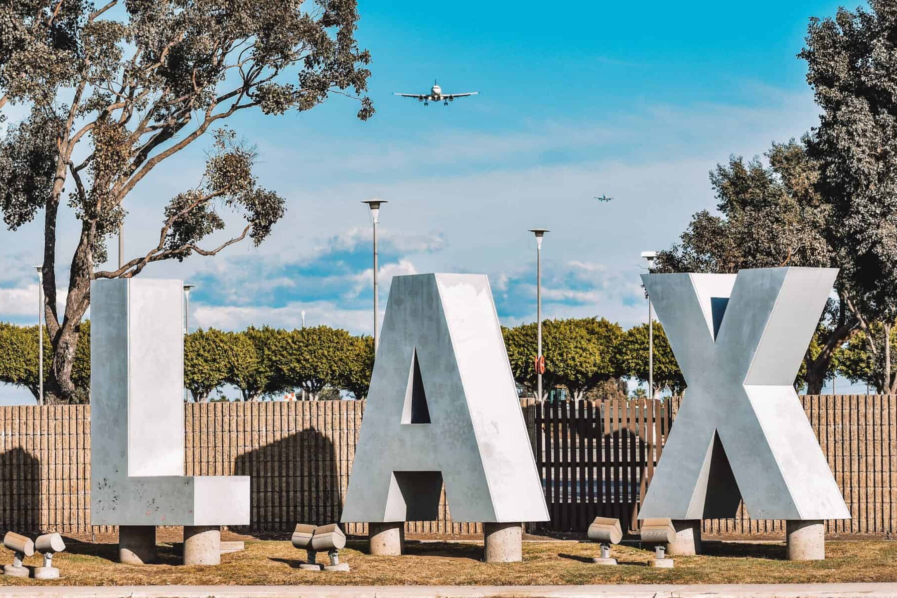 A shot of an aircraft taking off right over the LAX sign!