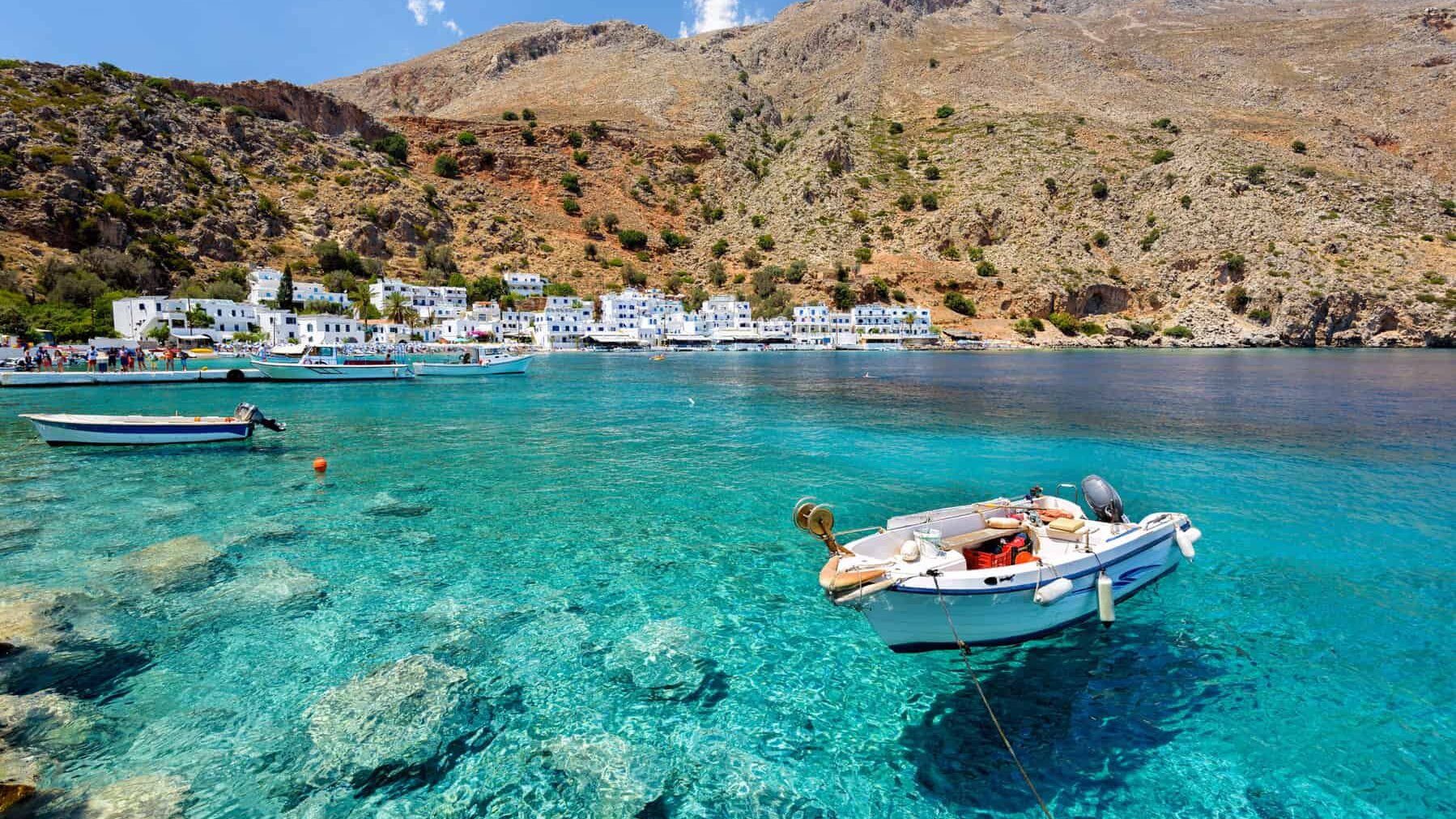 Pequeña lancha en la bahía de aguas claras de la ciudad de Loutro en la isla de Creta