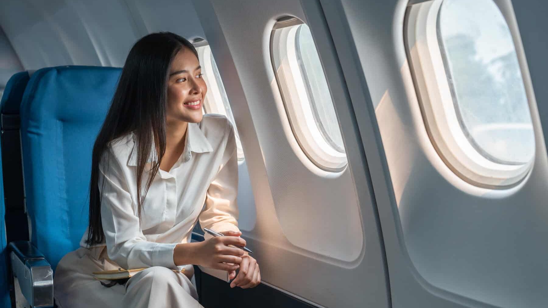 Asian woman sitting in a sellable seat in airplane
