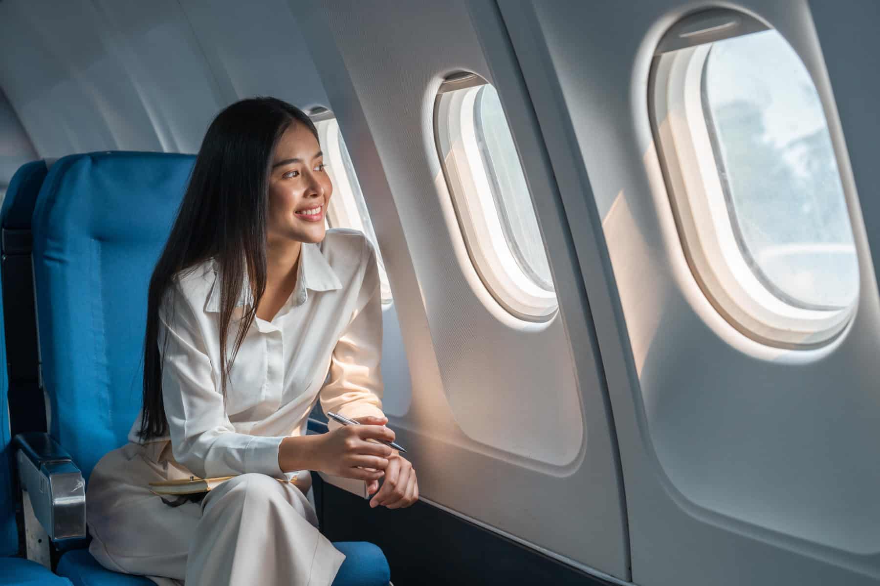 Asian woman sitting in a sellable seat in airplane